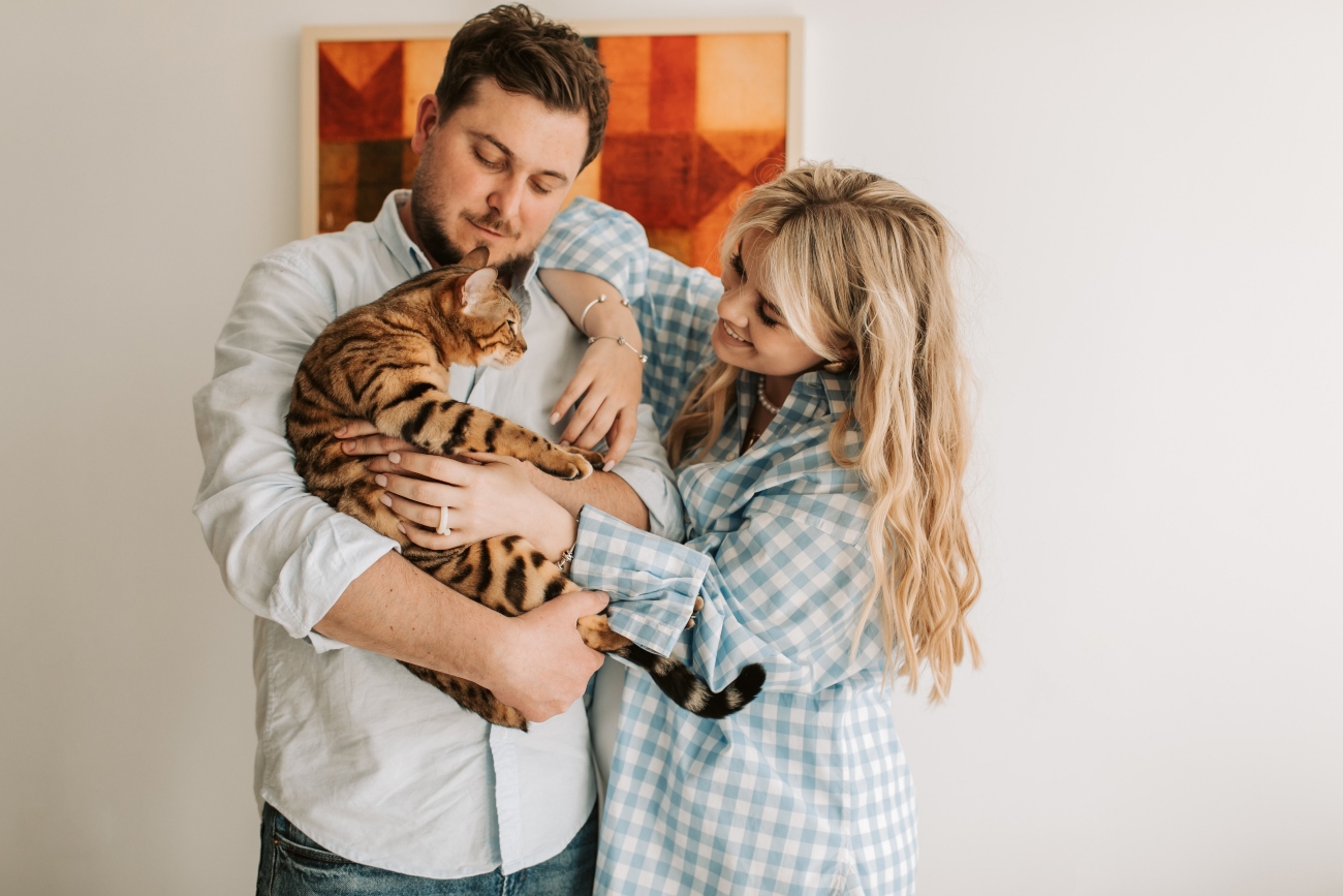 Young couple holding cat in their arms